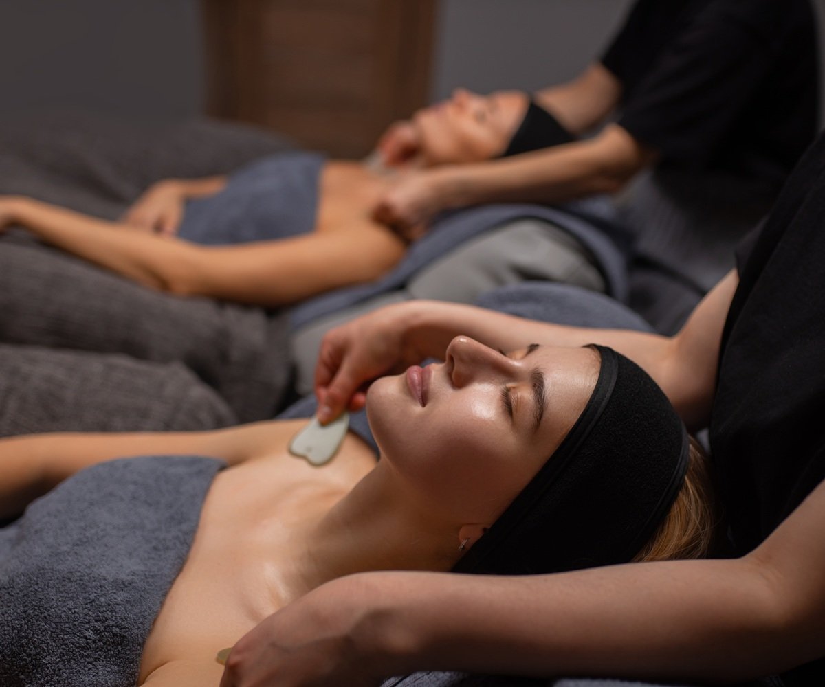 young and beautiful caucasian woman get massage on shoulders and neck with the use of cosmetic tools in luxury spa salon