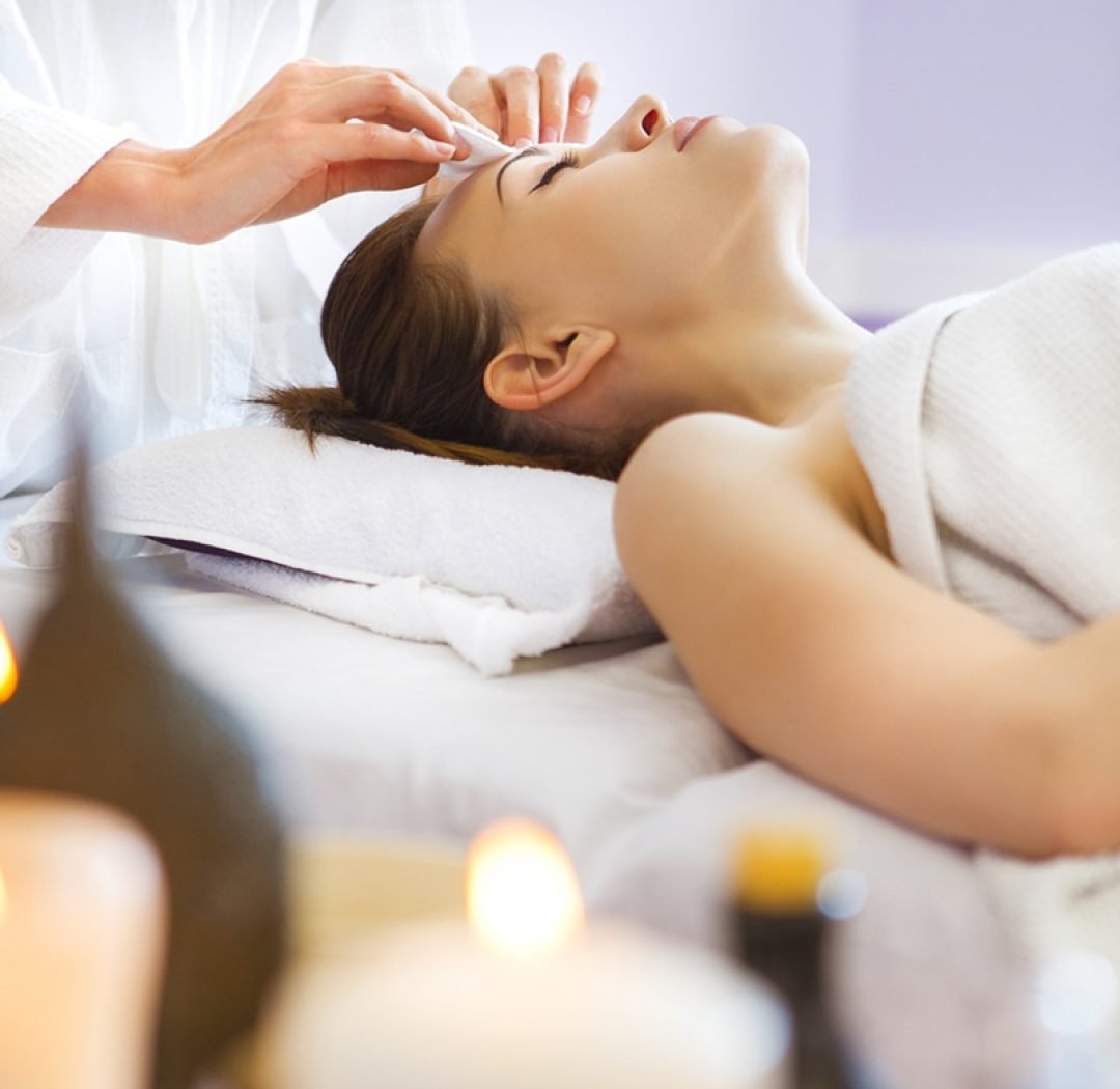 Relaxed woman with a deep cleansing nourishing face mask applied to her face. Spa treatment